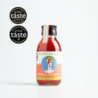 Load image into Gallery viewer, In the centre of the page is a single-serve cocktail in a cute looking small glass bottle, with a black aluminium cap. To the left of the page are some award logos from the Great Taste awards; one star in 2023 and a logo for a Great Taste producer. The cocktail is an Aperol Negroni and the label is orange and white. In the centre is a circle and a picture which looks like David Bowie as Ziggy Stardust in the centre, with a blue background. The cocktail is a deep orange/red colour.