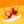 Load image into Gallery viewer, Two Aperol Negronis are in shot, in small short glasses with a ball of ice in each glass. They are on a short white stand, with two orange slices next to each glass. It&#39;s quite an arty shot, with the white stand being on a lemon yellow table, and the background is a nice orange colour. It&#39;s a bright, colourful fun picture. The cocktails look nicely chilled.
